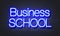 Business school neon sign on brick wall background.