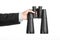 Business and search topic: Man in black suit holding a black binoculars in hand on white isolated background in studio