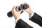 Business and search topic: Man in black suit holding a black binoculars in hand on white isolated background in studio