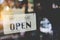 A business sign that says open on cafe or restaurant hang on door at entrance