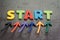 Business start or begin new life journey concept, colorful arrows point up to word START on blackboard cement wall