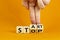 Business and stop or start concept.Male hand flips a wooden cube and changes the word `stop` to `start`. Beautiful orange