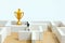 Business strategy conceptual photo - Miniature of businessman on a labyrinth maze seeking the golden trophy