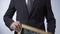 Business strategy written on blackboard, male in black suit holding sign, career