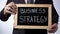 Business strategy written on blackboard, male in black suit holding sign, career