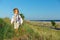 Business style baby boy walking the field near sea