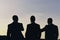 Business and success concept. Silhouettes of men standing against sunset. Leaders discuss project.