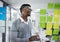 Business tablet, glass wall and black man planning, strategy or research in office workplace. Sticky notes