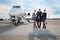 Business team standing in front of private jet