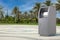 Business Technology Concept. ATM Deposit Machine on an Empty City Street with Palm Trees. 3d Rendering