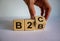 Business to Business or Busness to Consumer. Hand turns a cube and changes the expression `B2C` to `B2B` or vice versa. Busine