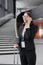 business tourism, business woman in a formal suit with a smartphone in a business center or airport with a suitcase goes