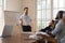 Business trainer stands in front of diverse team makes presentation