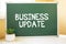 Business Update inscription in chalk on the school board, Search engine optimization and websites. Desk, swept balls of paper,