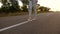 Business woman carries black briefcase with documents in hand. Women legs in white shoes and pants go on asphalt