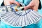 Business woman counting money in hands. Handful of money. Offering money. Women`s hands hold money denominations of 100 dollars.