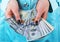 Business woman counting money in hands. Handful of money. Offering money. Women`s hands hold money denominations of 100 dollars.