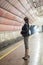 Business woman with a cup of coffee at subway station and train. Beautiful girl in sunglasses and a jacket at the subway station.