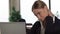Business woman feeling neck pain working on laptop in office, spinal problem