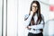 Business woman in formal clothes and eyesglasses in office with panoramic windows.