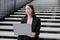 business woman in a formal suit with a laptop in an office or business center sits on the steps in the lobby and works