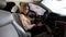 Business woman getting into car and fastening her seat belt, transport for rent