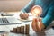 business woman hand holding lightbulb with coins stack on desk. concept saving energy