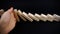 Business woman hand with red nails stopping the dominoes falling on dark background, business concept image