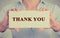 Business woman hands holding sign or card with message thank you