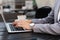 Business woman hands in suit is typing on a laptop in street cafe