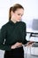 Business woman headshot in modern office. Secretary or female lawyer using tablet computer while standing straight