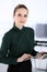 Business woman headshot in modern office. Secretary or female lawyer using tablet computer while standing straight