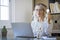 Business woman holding light bulb on the desk in office and using computer. Corporate portrait of home worker female people having