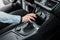 Business woman holds her hand on the gear selector automatic transmission