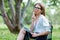 Business woman with a laptop sitting in the Park on a folding chair and holding a pen in her hand