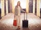 Business woman, luggage and happy in hotel hallway for portrait with suit, handbag and pride in lobby. Person