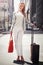 Business woman, luggage and portrait on sidewalk with smile for journey with walking, suit and outdoor. Person, happy