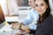 Business woman and man discussing questions while using computer at workplace in sunny office