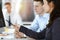 Business woman and man discussing questions while using computer at workplace in sunny office