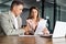 Business woman manager consulting man client showing documents at meeting.