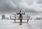 Business woman with megaphone on wooden bench