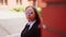 Business woman posing. Young woman in glasses, business suit on city street.