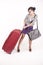 Business woman pulling heavy suitcase