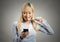 Business woman reading news on smartphone brushing teeth