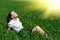Business woman relaxing in green grass field outdoor under sun. Beautiful young girl dressed in suit resting, spring landscape, br