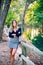 A business woman, secretary, dressed in a skirt and black blouse, smiling pretty at camera in a park with trees