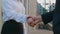 Business woman shakes hands with business man at meeting, agrees to deal or greets. Handshake between confident female