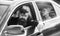 Business woman sit on backseat while bearded driver sit in front. Car with open windows and passenger. Business lady
