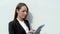 Business woman standing by the white glass wall with tablet