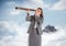 Business woman with telescope against mountain peak in the clouds